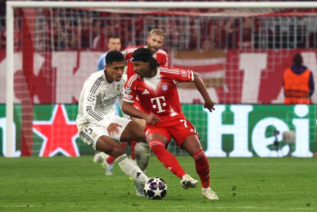 Real Madrid's English midfielder #05 Jude Bellingham (L) and Bayern Munich's German forward #07 Serge Gnabry vie for the ball during the UEFA Champions League quarter-final second leg football match between FC Bayern Munich and Real Madrid in Munich, southern Germany, on April 15, 2026. (Photo by Karl-Josef HILDENBRAND / AFP)