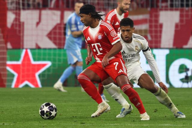 Real Madrid's English midfielder #05 Jude Bellingham (R) and Bayern Munich's German forward #07 Serge Gnabry vie for the ball during the UEFA Champions League quarter-final second leg football match between FC Bayern Munich and Real Madrid in Munich, southern Germany, on April 15, 2026. (Photo by Karl-Josef HILDENBRAND / AFP)