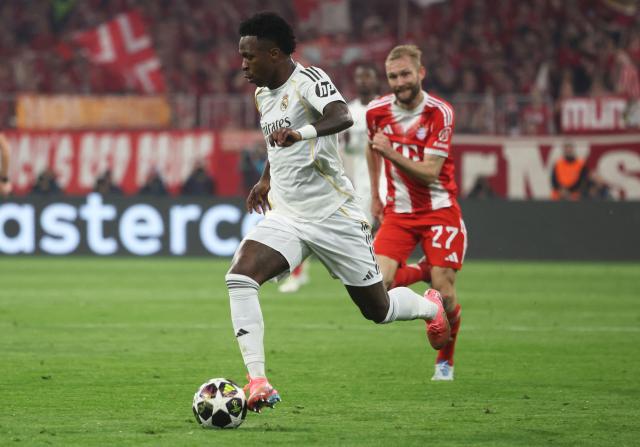Real Madrid's Brazilian forward #07 Vinicius Junior (L) and Bayern Munich's Austrian midfielder #27 Konrad Laimer vie for the ball during the UEFA Champions League quarter-final second leg football match between FC Bayern Munich and Real Madrid in Munich, southern Germany, on April 15, 2026. (Photo by Karl-Josef HILDENBRAND / AFP)