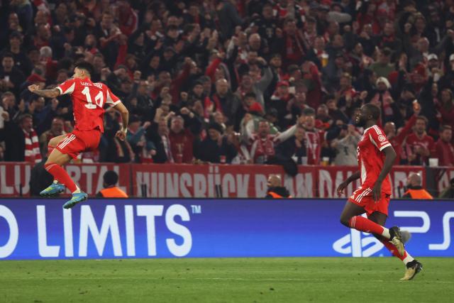 Bayern Munich's Colombian forward #14 Luis Diaz jumps to celebrate after (L) scoring the equalizing 3-3 goal during the UEFA Champions League quarter-final second leg football match between FC Bayern Munich and Real Madrid in Munich, southern Germany, on April 15, 2026. (Photo by Karl-Josef HILDENBRAND / AFP)