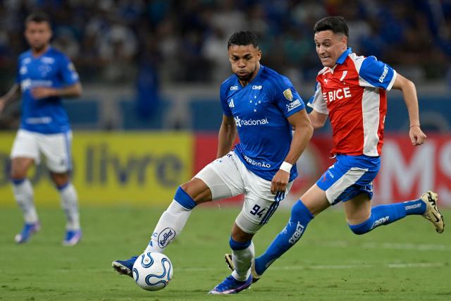 Cruzeiro's forward #94 Wanderson and Universidad Catolica's Argentine midfielder #08 Fernando Zuqui fight for the ball during the Copa Libertadores group stage football match between Brazil's Cruzeiro and Chile's Universidad Catolica at the Mineirao stadium in Belo Horizonte, state of Minas Gerais, Brazil, on April 15, 2026. (Photo by DOUGLAS MAGNO / AFP)