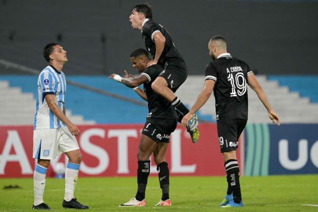Botafogo's forward #07 Junior Santos (bottom) celebrates scoring his team's second goal with teammates Venezuelan defender #05 Nahuel Ferraresi (top) and forward #19 Arthur Cabral (R) during the Copa Sudamericana group stage football match between Argentina's Racing Club and Brazil's Botafogo at the Presidente Peron 'El Cilindro' stadium, in Avellaneda, Buenos Aires province, Argentina on April 15, 2026. (Photo by JUAN MABROMATA / AFP)