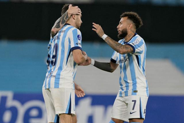 Racing's forward #09 Adrian Martinez (L) celebrates scoring his team's second goal with teammate Colombian forward #07 Duvan Vergara (R) during the Copa Sudamericana group stage football match between Argentina's Racing Club and Brazil's Botafogo at the Presidente Peron 'El Cilindro' stadium, in Avellaneda, Buenos Aires province, Argentina on April 15, 2026. (Photo by JUAN MABROMATA / AFP)
