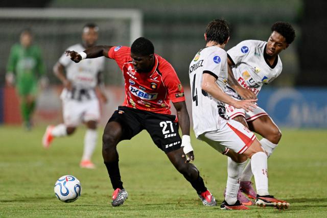Caracas' Colombian forward #27 Sebastian Gonzalez, Independiente Petrolero's defender #04 Francisco Rodriguez and Paraguayan defender #05 Luis Palma fight for the ball during the Copa Sudamericana group stage football match between Venezuela's Caracas FC and Bolivia's Independiente Petrolero at the Olimpico de la UCV stadium in Caracas on April 15, 2026. (Photo by Juan BARRETO / AFP)