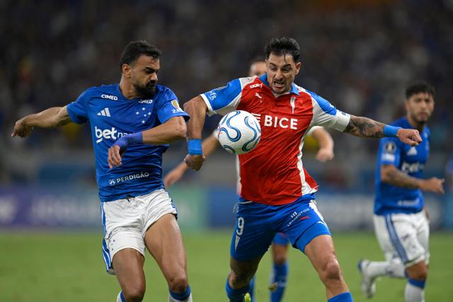 Cruzeiro's defender #15 Fabricio Bruno (L) and Universidad Catolica's Argentine forward #09 Fernando Zampedri fight for the ball during the Copa Libertadores group stage football match between Brazil's Cruzeiro and Chile's Universidad Catolica at the Mineirao stadium in Belo Horizonte, state of Minas Gerais, Brazil, on April 15, 2026. (Photo by DOUGLAS MAGNO / AFP)