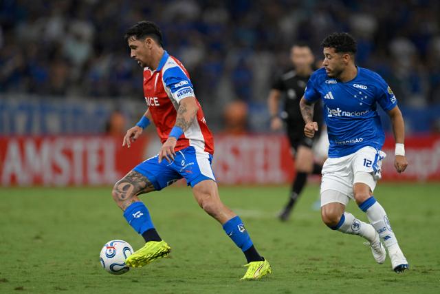 Universidad Catolica's Argentine forward #09 Fernando Zampedri controls the ball past Cruzeiro's defender #12 William during the Copa Libertadores group stage football match between Brazil's Cruzeiro and Chile's Universidad Catolica at the Mineirao stadium in Belo Horizonte, state of Minas Gerais, Brazil, on April 15, 2026. (Photo by DOUGLAS MAGNO / AFP)
