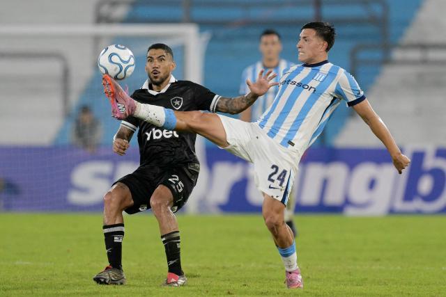 Racing's midfielder #24 Adrian Fernandez (R) controls the ball past Botafogo's midfielder #25 Allan (L) during the Copa Sudamericana group stage football match between Argentina's Racing Club and Brazil's Botafogo at the Presidente Peron 'El Cilindro' stadium, in Avellaneda, Buenos Aires province, Argentina on April 15, 2026. (Photo by JUAN MABROMATA / AFP)