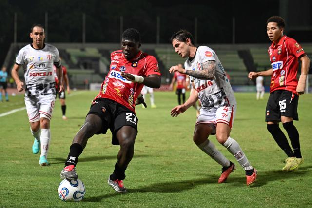 Caracas' Colombian forward #27 Sebastian Gonzalez controls the ball past Independiente Petrolero's defender #04 Francisco Rodriguez during the Copa Sudamericana group stage football match between Venezuela's Caracas FC and Bolivia's Independiente Petrolero at the Olimpico de la UCV stadium in Caracas on April 15, 2026. (Photo by Juan BARRETO / AFP)