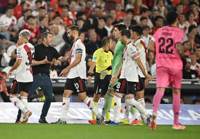 River Plate's head coach Eduardo Coudet speaks to his players during the cooling break of the Copa Sudamericana group stage football match between Argentina's River Plate and Venezuela's Carabobo at the Mas Monumental stadium in Buenos Aires on April 15, 2026. (Photo by Luis ROBAYO / AFP)