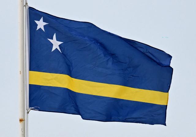 The Curacao flag is seen in Willemstad, Curacao, in the Dutch Caribbean, on April 8, 2026. Small island, big dreams. The poster of Curacao’s national football team hangs at the entrance of Marchena, a working-class neighborhood of Willemstad, the capital of the smallest territory ever to qualify for a World Cup. (Photo by Raul ARBOLEDA / AFP)