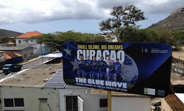 View of a banner depicting the Curacao national football team in Willemstad, in the Dutch Caribbean, on April 11, 2026. Small island, big dreams. The poster of Curacao’s national football team hangs at the entrance of Marchena, a working-class neighborhood of Willemstad, the capital of the smallest territory ever to qualify for a World Cup. (Photo by Raul ARBOLEDA / AFP)