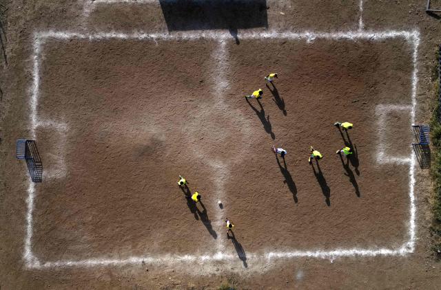 Aerial view of a training session of the Bicentini Foundation football school in the Fuik neighborhood, east of Willemstad, in the Dutch Caribbean, on April 11, 2026. Small island, big dreams. The poster of Curacao’s national football team hangs at the entrance of Marchena, a working-class neighborhood of Willemstad, the capital of the smallest territory ever to qualify for a World Cup. (Photo by Raul ARBOLEDA / AFP)