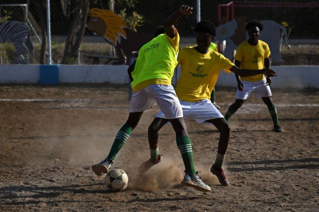 Football players take part in a training session of the Bicentini Foundation football school in the Fuik neighborhood, east of Willemstad, in the Dutch Caribbean, on April 11, 2026. Small island, big dreams. The poster of Curacao’s national football team hangs at the entrance of Marchena, a working-class neighborhood of Willemstad, the capital of the smallest territory ever to qualify for a World Cup. (Photo by Raul ARBOLEDA / AFP)