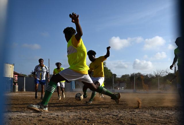 Football players take part in a training session of the Bicentini Foundation football school in the Fuik neighborhood, east of Willemstad, in the Dutch Caribbean, on April 11, 2026. Small island, big dreams. The poster of Curacao’s national football team hangs at the entrance of Marchena, a working-class neighborhood of Willemstad, the capital of the smallest territory ever to qualify for a World Cup. (Photo by Raul ARBOLEDA / AFP)
