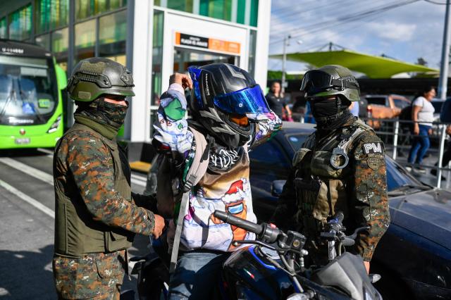 Guatemala's soldiers search motorcyclists at traffic lights stops in streets in Guatemala City on April 15, 2026. Military forces put in place the 'Sentinel Plan' which seeks to provide security in the metropolitan area to curb extortion and neutralize gang operations. (Photo by JOHAN ORDONEZ / AFP)