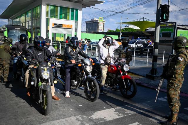 Guatemala's soldiers search motorcyclists at traffic lights stops in streets in Guatemala City on April 15, 2026. Military forces put in place the 'Sentinel Plan' which seeks to provide security in the metropolitan area to curb extortion and neutralize gang operations. (Photo by JOHAN ORDONEZ / AFP)