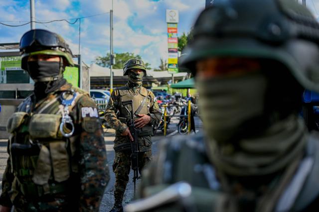 Guatemala's soldiers stand guard on a street of Guatemala City on April 15, 2026. Military forces put in place the 'Sentinel Plan' which seeks to provide security in the metropolitan area to curb extortion and neutralize gang operations. (Photo by JOHAN ORDONEZ / AFP)