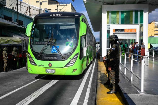 Guatemala's soldiers stand guard on a bus stop in Guatemala City on April 15, 2026. Military forces put in place the 'Sentinel Plan' which seeks to provide security in the metropolitan area to curb extortion and neutralize gang operations. (Photo by JOHAN ORDONEZ / AFP)