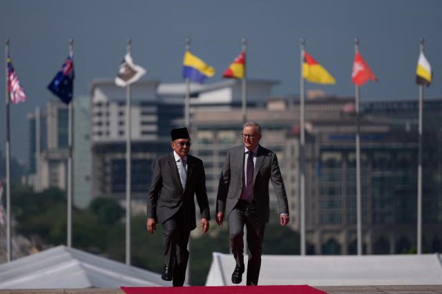 Australia's Prime Minister Anthony Albanese (L) walks with Malaysia's Prime Minister Anwar Ibrahim after an official welcoming ceremony at the Federal Government office "Putra Perdana" in Putrajaya on April 16, 2026. (Photo by Vincent Thian / POOL / AFP)