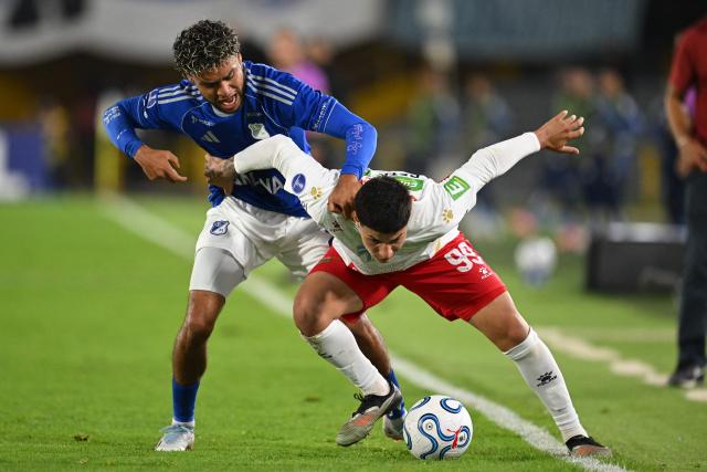 Millonarios defender #22 Sebastian Valencia and Boston River's Argentine midfielder #99 Gonzalo Reyna fight for the ball during the Copa Sudamericana group stage football match between Colombia's Millonarios and Uruguay's Boston River at the Nemesio Camacho El Campin Stadium in Bogota on April 15, 2026. (Photo by Raul ARBOLEDA / AFP)