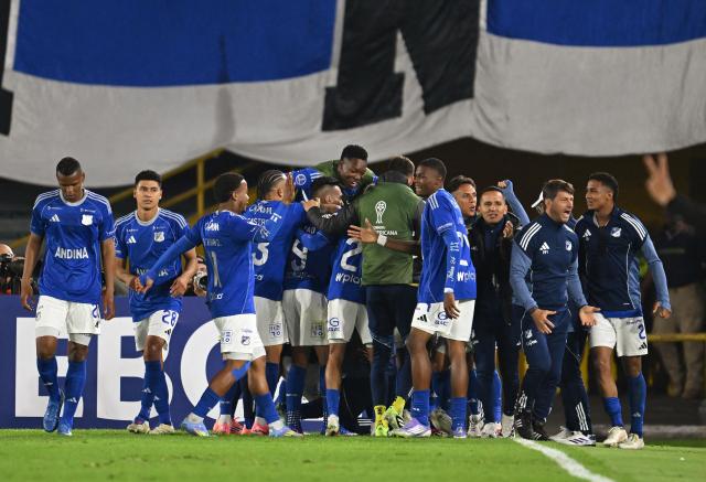 Millonarios players celebrate after scoring the opening goal during the Copa Sudamericana group stage football match between Colombia's Millonarios and Uruguay's Boston River at the Nemesio Camacho El Campin Stadium in Bogota on April 15, 2026. (Photo by Raul ARBOLEDA / AFP)
