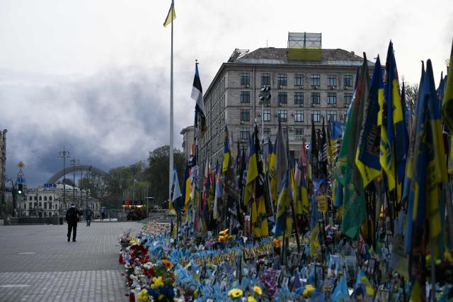 A person walks along a street as smoke rises over Kyiv following a Russian strike on April 16, 2026, amid the Russian invasion of Ukraine. Russian strikes killed at least 12 people in Ukraine, local authorities said on April 16, after Moscow pummelled its neighbour in overnight attacks. (Photo by Genya SAVILOV / AFP)