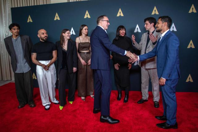 Academy of Motion Picture Arts and Sciences CEO Bill Kramer (4R) greets the recipients of the 2026 Academy Nicholl Fellowship in Screenwriting (L/R) Leo Aguirre, Elie El Choufany, Katla Solnes, Sara Crwo, Lynn McKee, David Rafailades and Omar Al Dakheel as they attend the Academy Nicholl Fellowships in Screenwriting ceremony at the Beverly Hills Hotel in Beverly Hills, California, on April 15, 2026. (Photo by Apu GOMES / AFP)