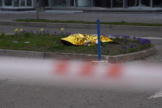 The body of a civilian lies on the ground following a Russian strike in Kyiv on April 16, 2026, amid the Russian invasion of Ukraine. Russian strikes killed at least 12 people in Ukraine, local authorities said on April 16, after Moscow pummelled its neighbour in overnight attacks. (Photo by Serhii Okunev / AFP)