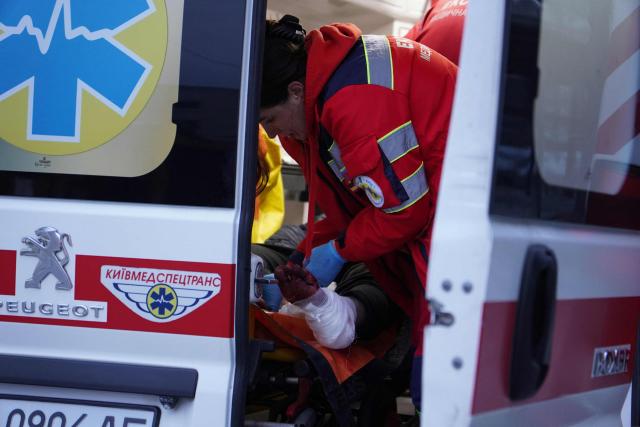 An emergency medical worker provides assistance to an injured person following a Russian strike in Kyiv on April 16, 2026, amid the Russian invasion of Ukraine. Russian strikes killed at least 12 people in Ukraine, local authorities said on April 16, after Moscow pummelled its neighbour in overnight attacks. (Photo by Serhii Okunev / AFP)
