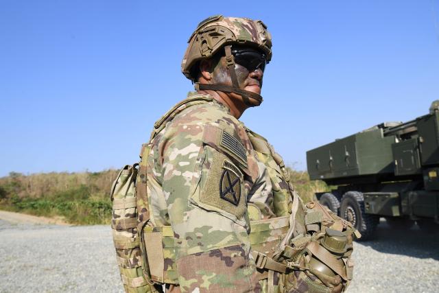 A US soldier stands next to one of their High Mobility Artillery Rocket System (HIMARS) launchers (R) during a joint exercise between the Philippines and the US at Fort Magsaysay, in the Philippines' Nueva Ecija province north of Manila on April 16, 2026. (Photo by Ted ALJIBE / AFP)