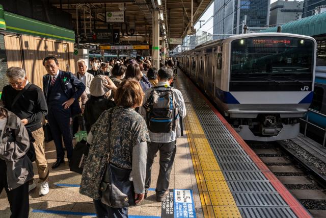 People wait for a train at Tokyo Station in Tokyo on April 16, 2026. (Photo by Yuichi YAMAZAKI / AFP)