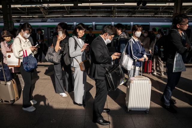 People wait for a train at Tokyo Station in Tokyo on April 16, 2026. (Photo by Yuichi YAMAZAKI / AFP)