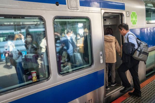 People board a train at Tokyo Station in Tokyo on April 16, 2026. (Photo by Yuichi YAMAZAKI / AFP)