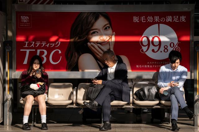 People sit on a bench on a platform at Tokyo Station in Tokyo on April 16, 2026. (Photo by Yuichi YAMAZAKI / AFP)