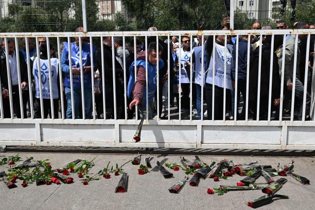 Mourners display roses at the entrance gate of the Ayser Calik college ahead of the funerals for nine victims killed in a school shooting by a 14-year-old, an attack that has sent shockwaves across the country, with authorities saying the suspect had referenced a US mass killer in a WhatsApp profile image, in the southern province of Kahramanmaras on April 16, 2026. The funerals take place for eight children aged 10 and 11 and a 55-year-old teacher. (Photo by YASIN AKGUL / AFP)