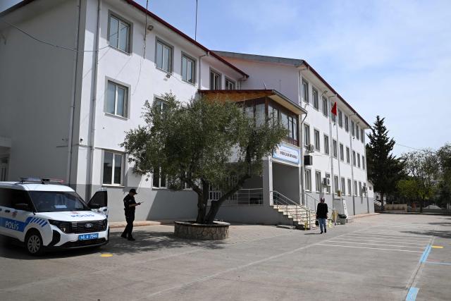 A Police officer stands guard near the Ayser Calik college ahead of the funerals for nine victims killed in a school shooting by a 14-year-old, an attack that has sent shockwaves across the country, with authorities saying the suspect had referenced a US mass killer in a WhatsApp profile image, in the southern province of Kahramanmaras on April 16, 2026. The funerals take place for eight children aged 10 and 11 and a 55-year-old teacher. (Photo by YASIN AKGUL / AFP)