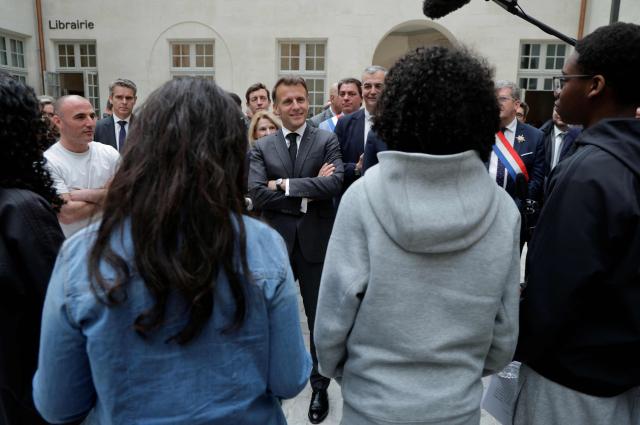 France's President Emmanuel Macron (C) speaks with middle school students upon his arrival at the International City of French Language (Cite Internationale de la Langue Francaise) to promote 'disconnecting' and 'reading' as alternatives to screens as part of his fight to ban social networks for the youngest in the castle of Villers-Cotterets, northern France on April 16, 2026. In response to the explosion in screen time among 6- to 17-year-olds and the impact of algorithms on our children, Emmanuel Macron has pledged to ban social media for those under 15. (Photo by Ludovic MARIN / POOL / AFP)