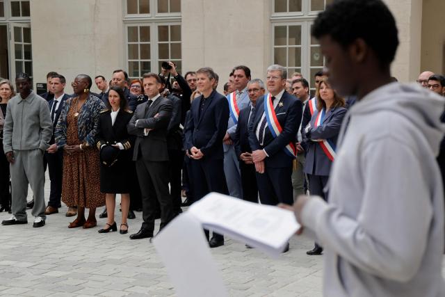 France's President Emmanuel Macron (C) listens to middle school students during his visit to the International City of French Language (Cite Internationale de la Langue Francaise) to promote 'disconnecting' and 'reading' as alternatives to screens as part of his fight to ban social networks for the youngest in the castle of Villers-Cotterets, northern France on April 16, 2026. In response to the explosion in screen time among 6- to 17-year-olds and the impact of algorithms on our children, Emmanuel Macron has pledged to ban social media for those under 15. (Photo by Ludovic MARIN / POOL / AFP)