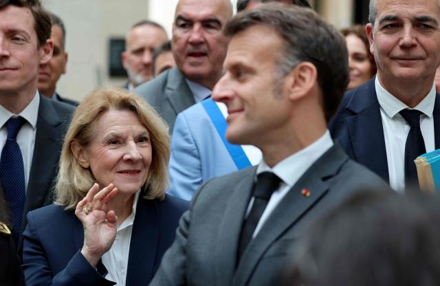 France's Culture Minister Catherine Pegard (L) gestures next France's President Emmanuel Macron (C) during a visit the International City of French Language (Cite Internationale de la Langue Francaise) to promote 'disconnecting' and 'reading' as alternatives to screens as part of his fight to ban social networks for the youngest in the castle of Villers-Cotterets, northern France on April 16, 2026. In response to the explosion in screen time among 6- to 17-year-olds and the impact of algorithms on our children, Emmanuel Macron has pledged to ban social media for those under 15. (Photo by Ludovic MARIN / POOL / AFP)