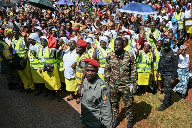 Supporters of Pope Leo XIV gather next to the road ahead of the Holy Mass at Bamenda Airport in Bamenda, on the fourth day of an 11-day apostolic journey to Africa, on April 16, 2026. (Photo by Alberto PIZZOLI / AFP)