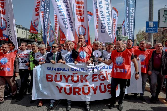 Teachers and members of education unions march as they hold a banner which reads "The Great Education March for Safe Schools and Healthy Education." during a protest against school shootings, in Ankara on April 16, 2026. More than 3,500 teachers from several education unions protested in the Turkish capital Ankara on  following deadly school shootings, calling for the resignation of the education minister. (Photo by ADEM ALTAN / AFP)