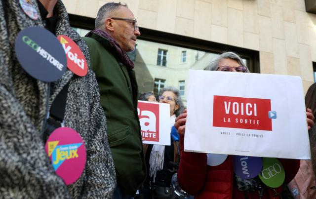 Employees of the leading magazine publisher in France Prisma Group gather during a demonstration against the Employment Protection Plan (PSE) in front of a building of the Prisma Media Group in Paris on April 16, 2026. Prisma Group announced to staff representatives on March 30, 2026 a plan to cut 261 jobs, representing 40% of its workforce, according to the CGT union. (Photo by Alain JOCARD / AFP)