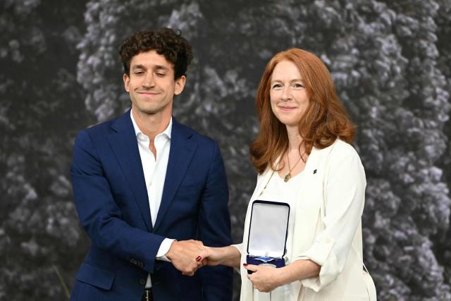 British journalist and the chief executive of the Committee to Protect Journalists Jodie Ginsberg, on behalf of the US nonprofit organization Committee to Protect Journalists (CPJ), receives from the hand of Dutch journalist Pjotr Sauer (L) the Freedom of Speech award during the Roosevelt Foundation's International Four Freedoms Awards ceremony in Middelburg on April 16, 2026. (Photo by NICOLAS TUCAT / AFP)