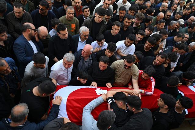 Family members and mourners attend the funerals for nine victims killed in a school shooting by a 14-year-old, an attack that has sent shockwaves across the country, with authorities saying the suspect had referenced a US mass killer in a WhatsApp profile image, in the southern province of Kahramanmaras on April 16, 2026. The funerals take place for eight children aged 10 and 11 and a 55-year-old teacher. (Photo by YASIN AKGUL / AFP)