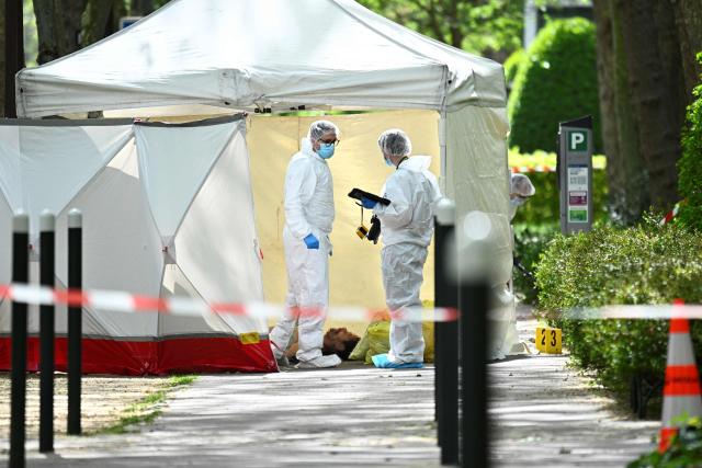 EDITORS NOTE: Graphic content / Police forensic personnel work beside a tent covering the body of French businessman Eric Robic in Neuilly-sur-Seine on the outskirts of Paris on April 16, 2026. A businessman known for fraud was shot dead in broad daylight in the middle of the street in Neuilly-sur-Seine (Hauts-de-Seine), an upscale suburb in western Paris, AFP learned from a source close to the case, confirming a report by Le Parisien. (Photo by JULIEN DE ROSA / AFP)
