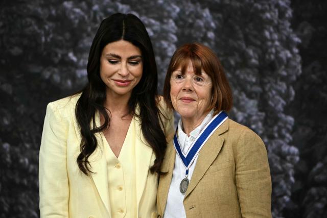 Frenchwoman Gisèle Pelicot, whose husband was convicted in 2024 of drugging her and letting scores of men rape her while unconscious, receives from the hand of Dutch fashion designer and entrepreneur Olcay Gulsen (L) the Freedom from Fear award during the Roosevelt Foundation's International Four Freedoms Awards ceremony in Middelburg on April 16, 2026. (Photo by NICOLAS TUCAT / AFP)