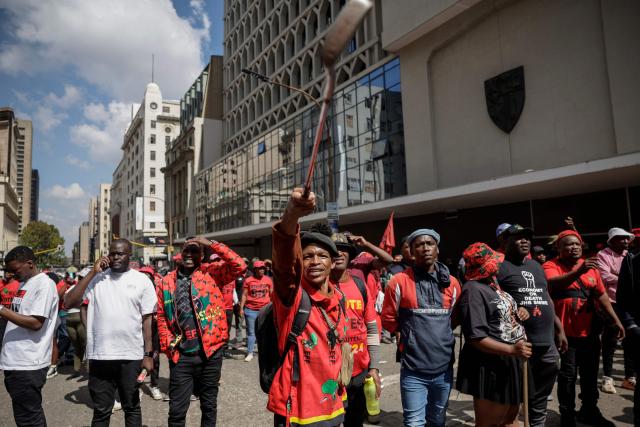 Supporters of the Economic Freedom Fighters (EFF) leader Julius Malema gesture in Johannesburg on April 16, 2026 as they react to a ruling by a South African court in KuGompo, formerly called East London, that sentenced him to five years in jail for firing an assault rifle at a rally eight years ago. (Photo by Phill MAGAKOE / AFP)