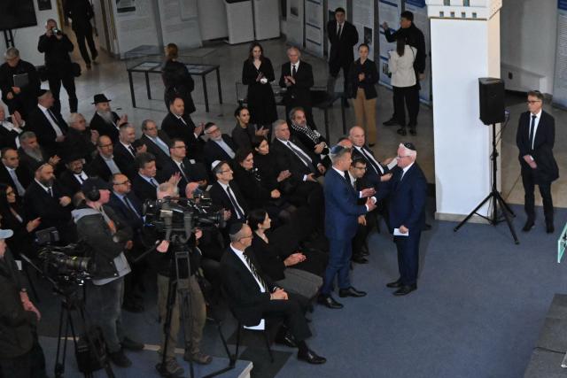 Hungary's Prime minister-elect Peter Magyar (C) and the president of the Federation of Hungarian Jewish Communities (MAZSIHISZ) Andor Grosz shake hands as members of the local Jewish community and diplomats participate on a commemoration ceremony for Hungarian Holocaust victims at the Holocaust Memorial Center in Budapest, Hungary on April 16, 2026. April 16, 2026 marks the 82th anniversary of the beginning of the Hungarian Holocaust during which some 600,000 Jewish Hungarians were deported to Nazi death camps in Austria, Germany and Poland. The Memorial Day of the Hungarian Victims of the Holocaust was established by the Ministry of Education in 2000 and is commemorated in schools, at memorial sites and by Jewish communities throughout the country. (Photo by Attila KISBENEDEK / AFP)