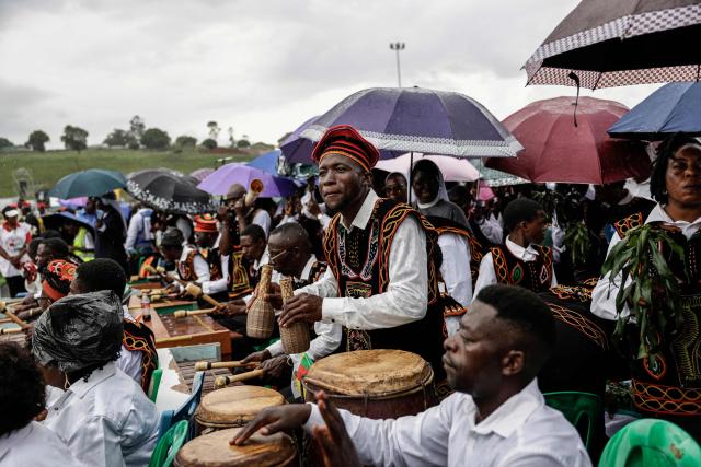 A man plays drums as they wait for Pope Leo XIV to arrive to lead the Holy Mass at Bamenda Airport in Bamenda, on the fourth day of an 11-day apostolic journey to Africa, on April 16, 2026. (Photo by Patrick MEINHARDT / AFP)