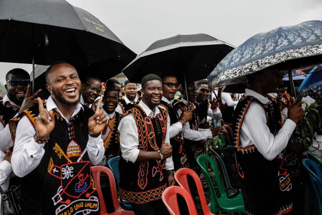 People sing as they wait for Pope Leo XIV to arrive to lead the Holy Mass at Bamenda Airport in Bamenda, on the fourth day of an 11-day apostolic journey to Africa, on April 16, 2026. (Photo by Patrick MEINHARDT / AFP)